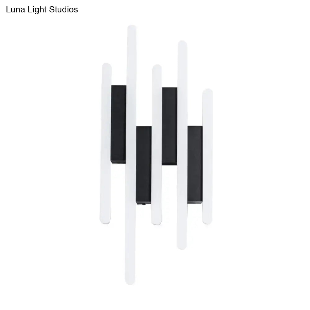 Modern minimalist black and white led wall sconce with sleek vertical bars emitting warm white light for bedroom use