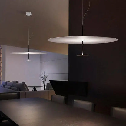 Modern minimalist black and white saucer pendant light with sleek circular diffuser and thin black cord pendant installation