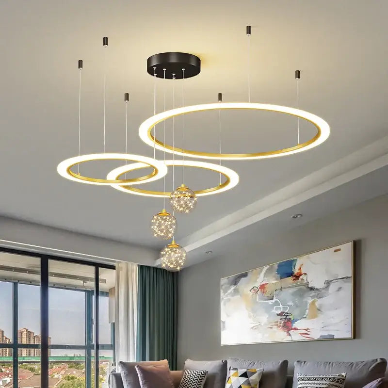 Modern minimalist gold-toned decorbites circle ring pendant chandelier with glowing led rings and crystal accents for living room
