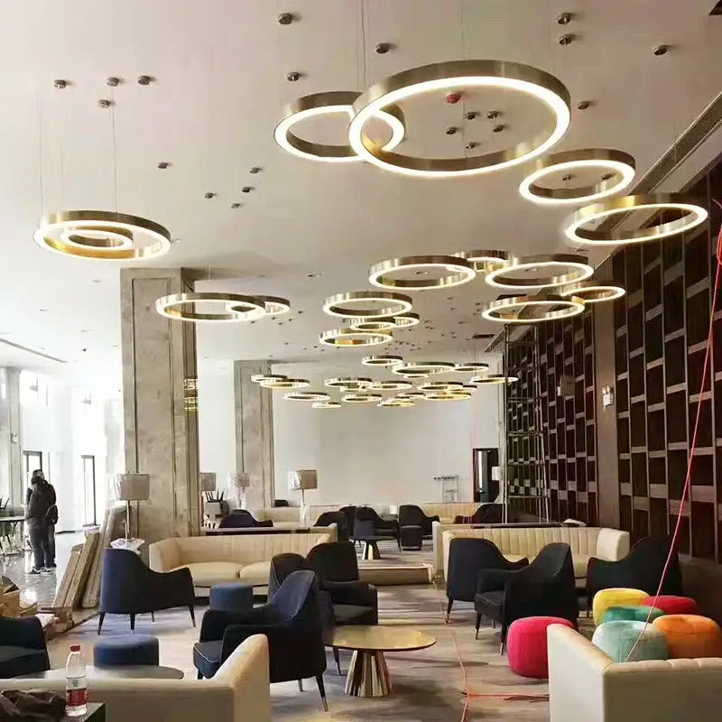 Modern minimalist circular gold ring pendant light features illuminated gold-toned rings for dining room decorbites circular gold