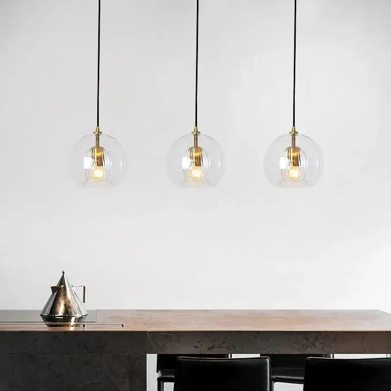 Modern minimalist pendant light with clear glass ball and brass accents by decorbites for dining room decor