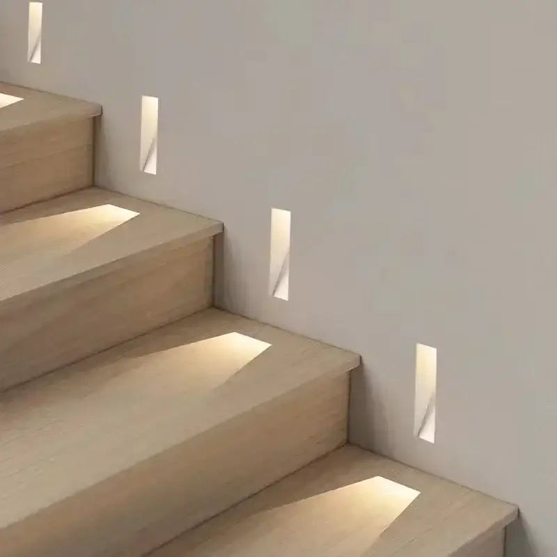 Modern minimalist concrete led underground lamp with recessed fixtures casting warm light on wooden garden stairway steps