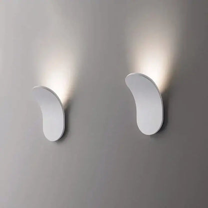 Modern minimalist curved metal led wall lamps with sleek white design emitting warm light for living room use