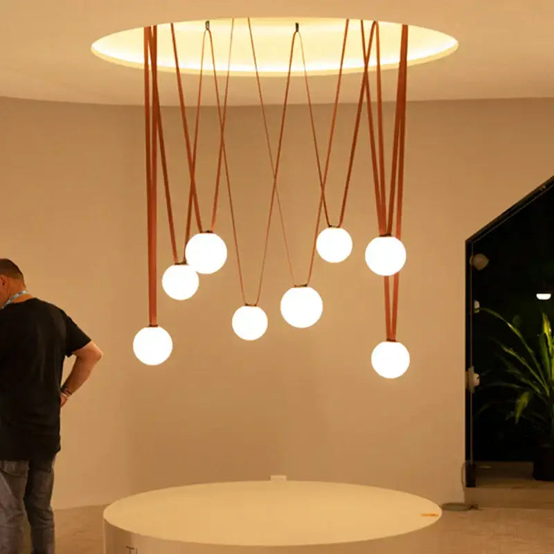 Modern minimalist frosted glass ball pendant light with seven white bulbs on brown leather cords for dining room decorbites glass ball