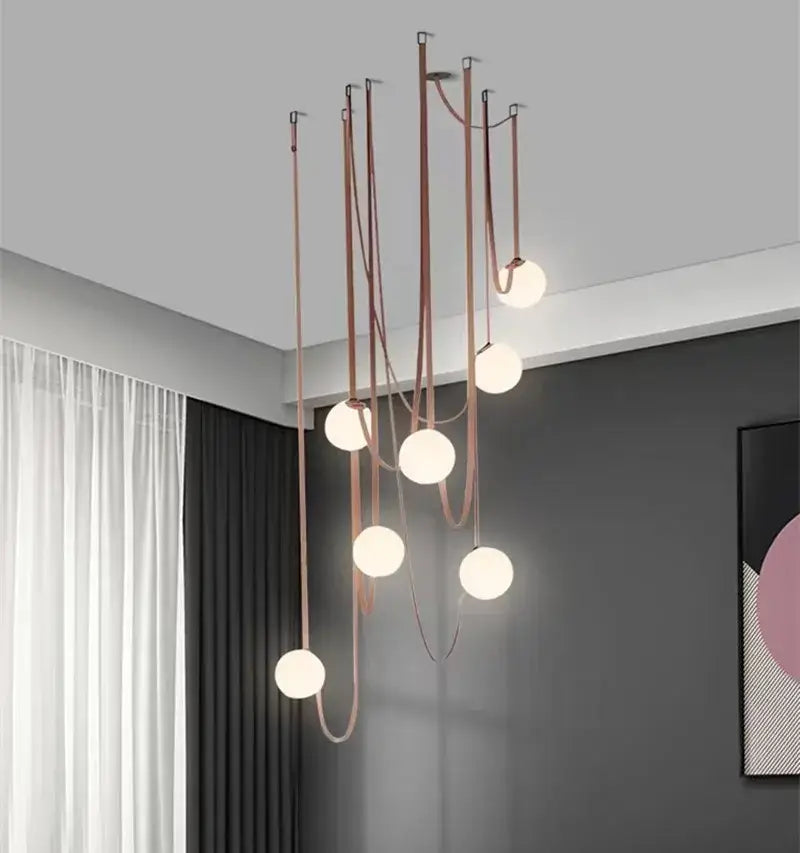 Modern minimalist pendant light with copper-toned curved rods and frosted glass ball bulbs for dining room decorbites glass ball