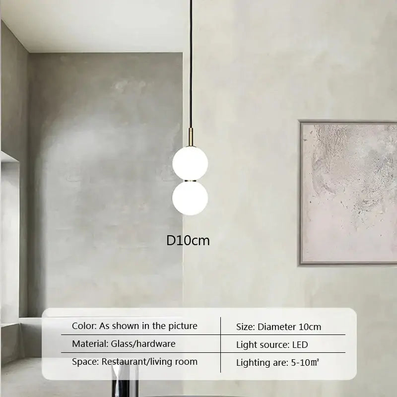 Modern minimalist pendant light with two frosted glass ball spheres on a slender brass rod for living room decorbites
