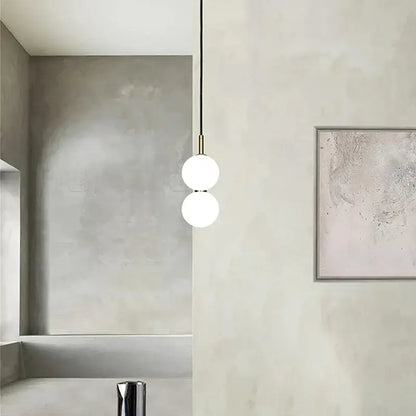 Modern minimalist pendant light with two frosted glass ball spheres and brass decorbites glass ball pendant hardware