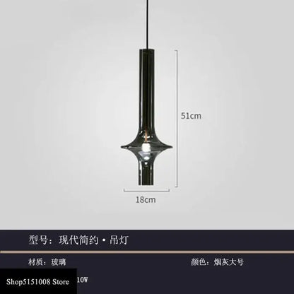 A sleek modern glass pendant light with smoked gray cylindrical glass body for kitchen hanging illumination