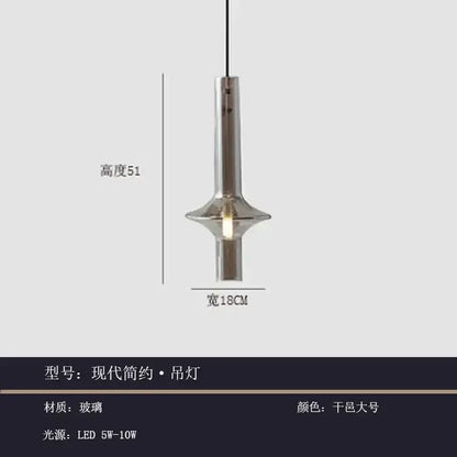 Modern minimalist glass pendant light with a sleek cylindrical glass body and metallic finish for kitchen use
