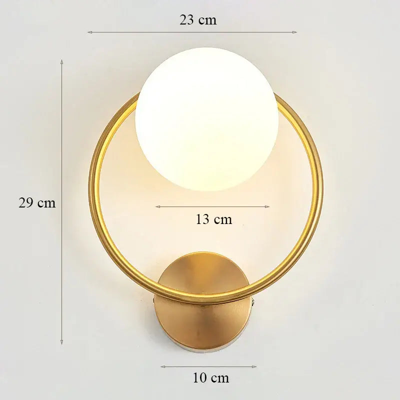 Modern minimalist wall lamp featuring a gold-toned circular base with a frosted white glass shade for bedroom use