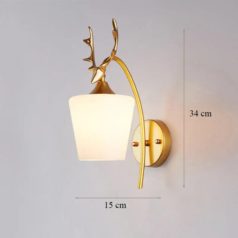 Modern minimalist wall lamp with gold-toned deer antler design and frosted white glass shade for bedroom use