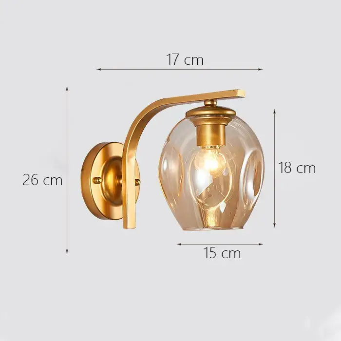 Modern minimalist wall lamp with a glass shade gold featuring a curved metal arm and textured glass globe for bedroom use