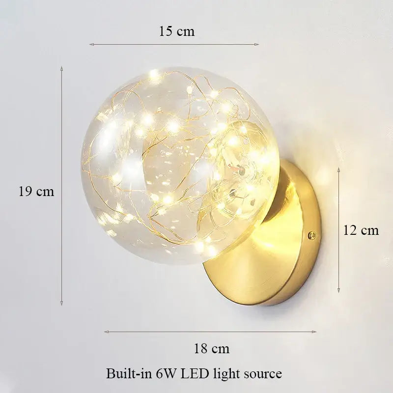 Modern minimalist wall lamp with glass shade gold tone and clear globe housing delicate string lights for bedroom