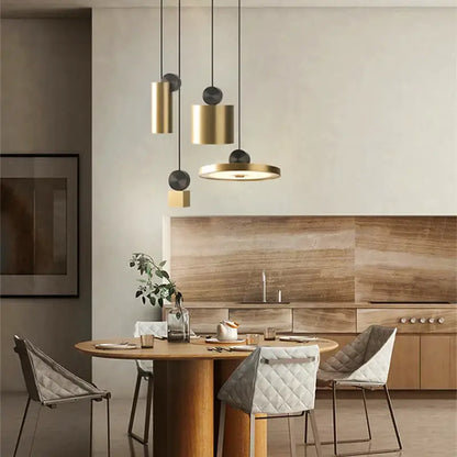 Modern minimalist golden led pendant light with brass and black cylindrical shades hanging above wooden dining table decorbites golden led pendant