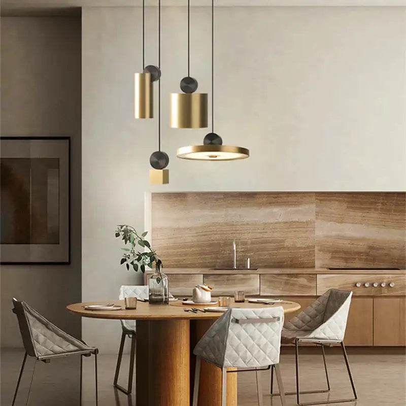 Modern minimalist golden led pendant light with brass and black cylindrical shades hanging above wooden dining table decorbites golden led pendant