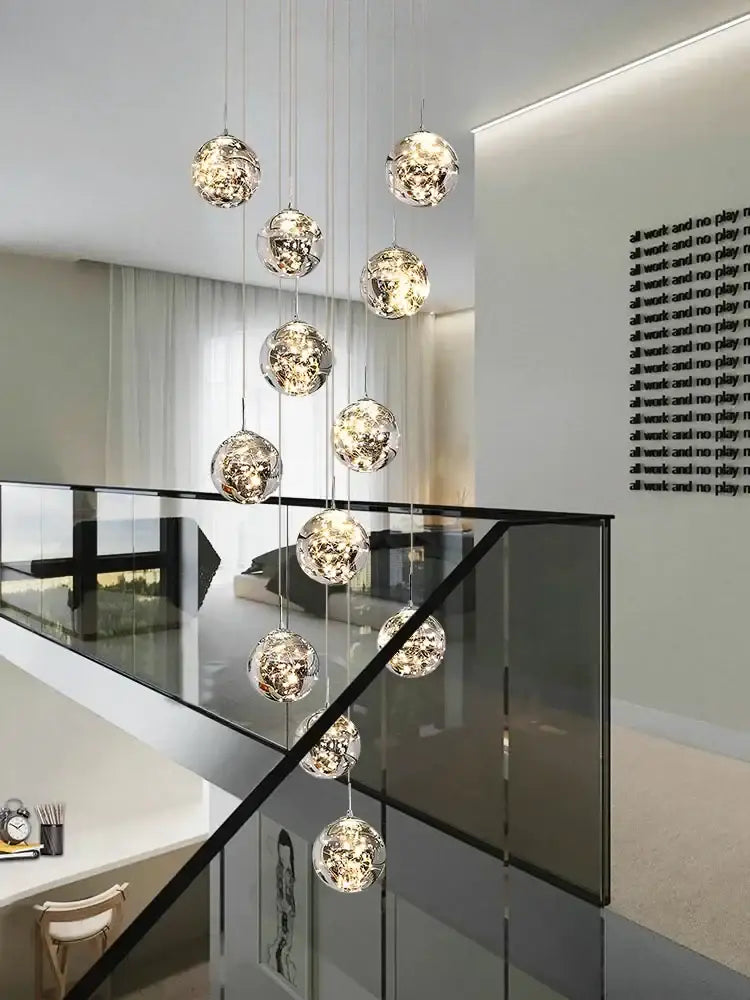 A modern minimalist gold decorbites glass chandelier with spherical orbs and intricate internal lighting for staircase lighting