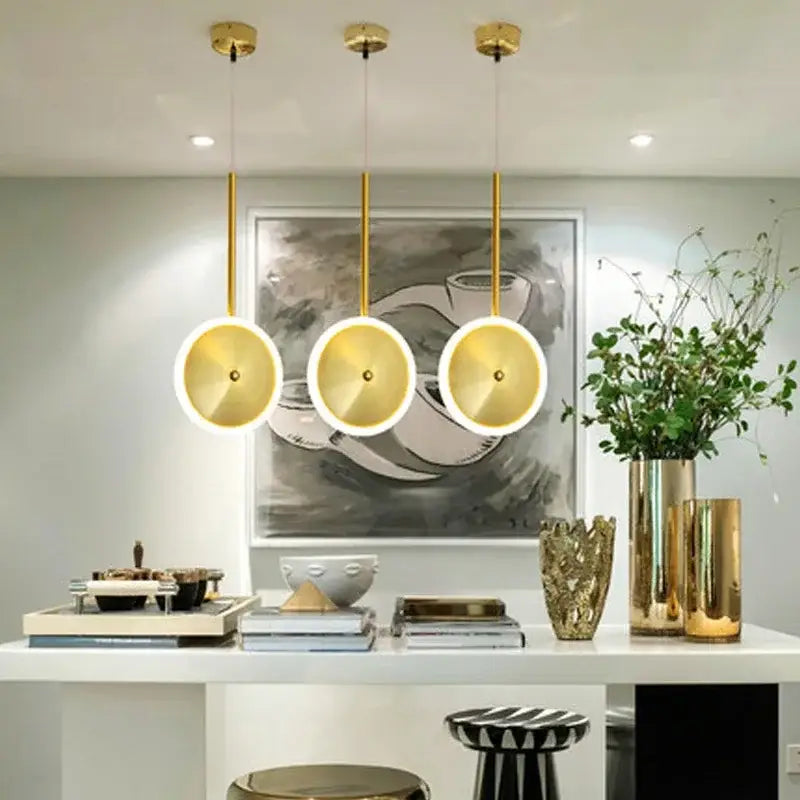 Three modern gold led pendant lights with circular disc-shaped shades for kitchen island decor by decorbites gold led