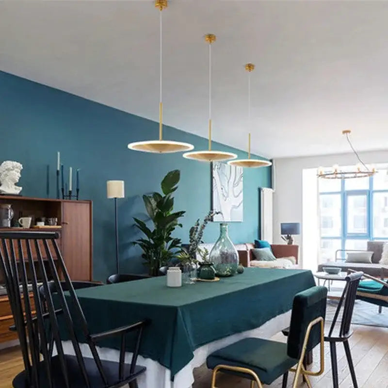 Three modern gold led pendant lights with circular flat shades hang from the ceiling for kitchen island decorbites decor