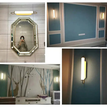 Modern minimalist gold led wall lamp with cylindrical sconce mounted above tiled wall below octagonal mirror