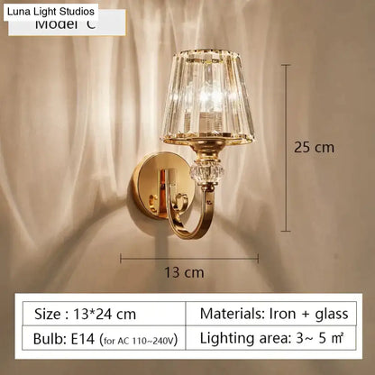 Modern minimalist wall sconce gold toned with faceted crystal glass shade and decorative accents for bedroom lighting