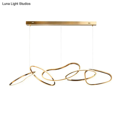 Modern minimalist golden led hanging light with sleek interlocking rings suspended from brass fixture for dining room