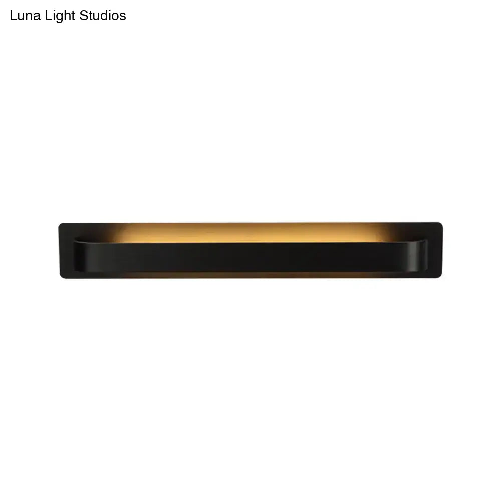 Black rectangular wall lamp with sleek modern design and warm golden illumination for living room lighting