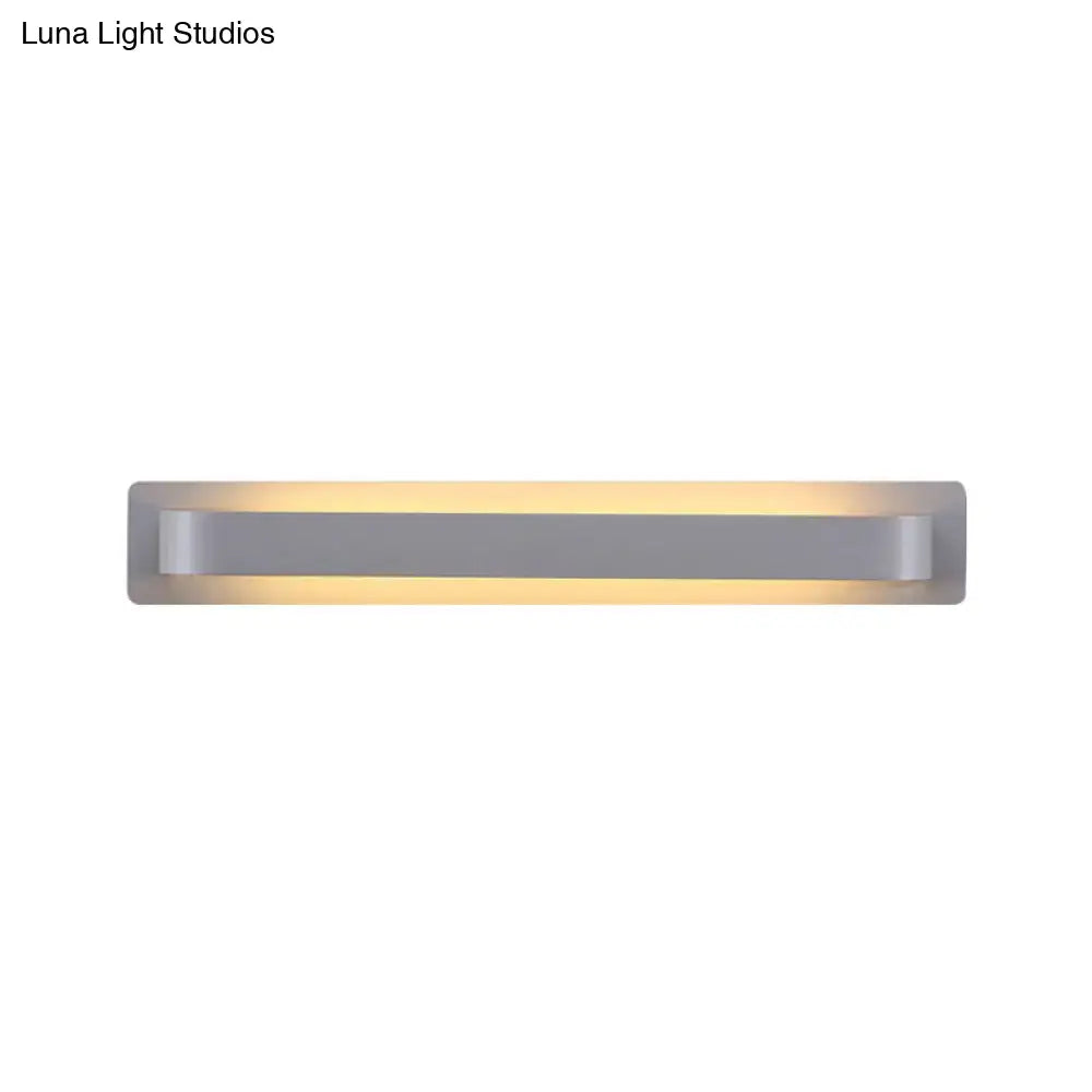Modern minimalist silver rectangular wall lamp with sleek design and warm ambient lighting for living room use