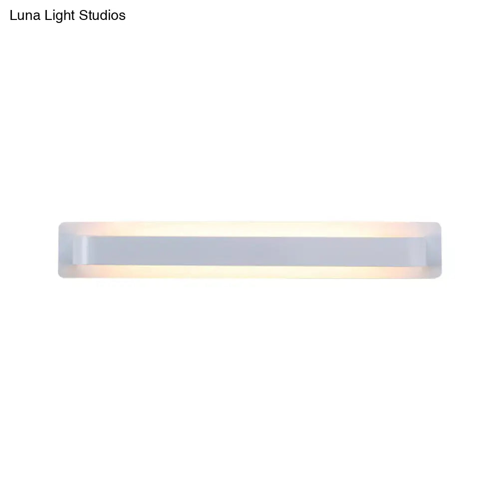 Modern minimalist silver linear wall lamp with a sleek rectangular design and frosted glass diffuser emitting warm light