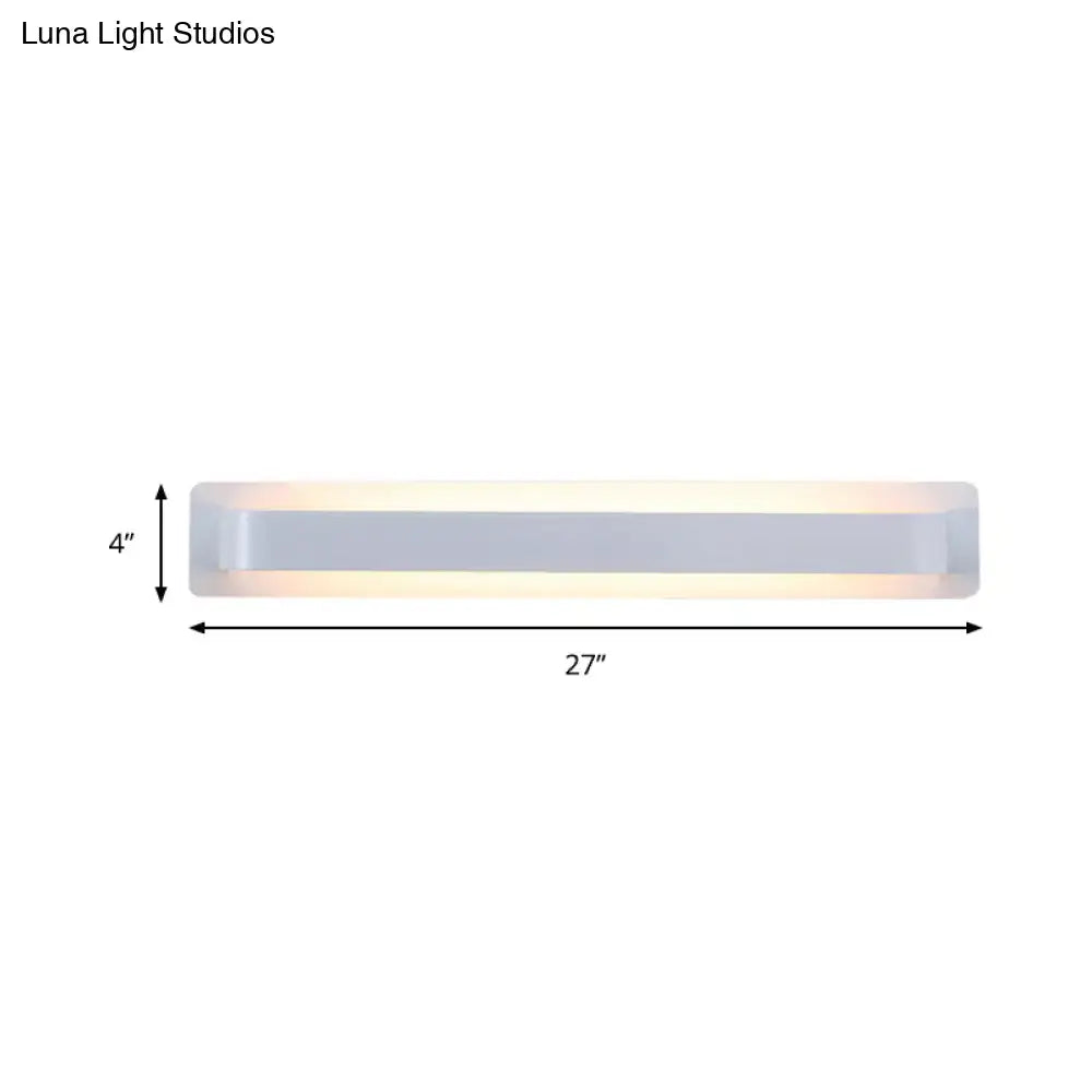 A sleek modern silver wall lamp with frosted glass diffuser and metallic frame for minimalist living room decor