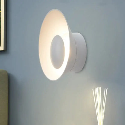 White circular wall lamp with modern minimalist design and soft ambient LED lighting for living room use