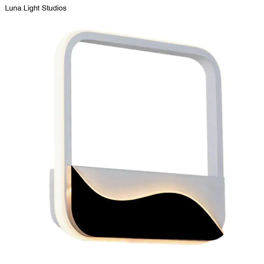 Modern minimalist white and black led wall mount sconce with sleek frame and warm white light for bedroom ambiance