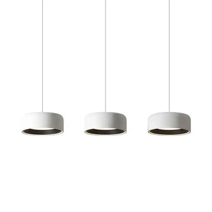 Three minimalist white cylindrical pendant lights with dark inner rims in decorbites designer led chandelier for dining room decor