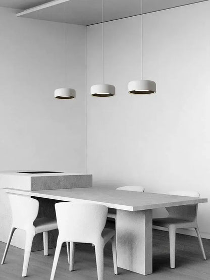 Minimalist white concrete dining table with built-in sink and chairs under a decorbites designer led chandelier pendant