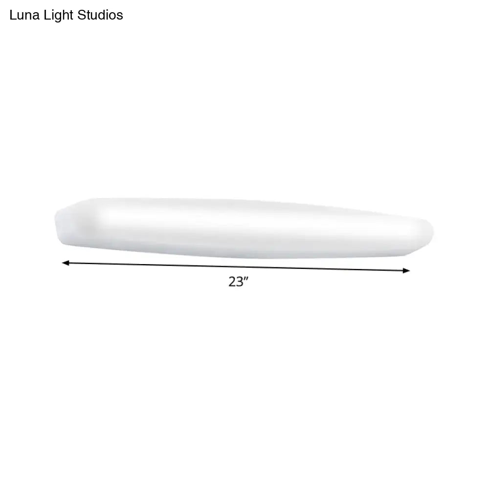 A sleek 23-inch white led wall light with modern elongated oval design emitting warm white light for bedroom use