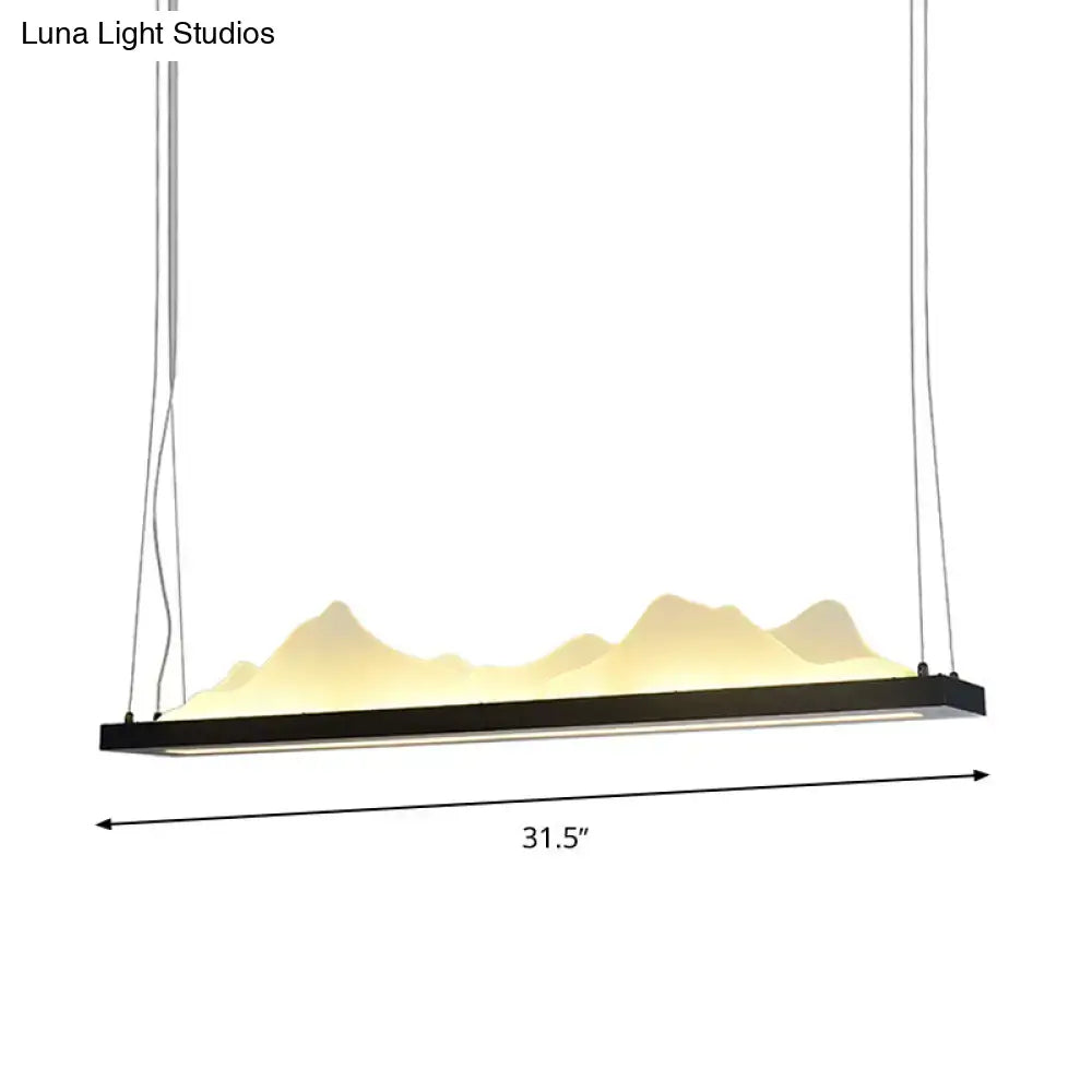 Black acrylic mountain-shaped pendant light with warm yellow led illumination and fixture width of 31.5 to 39 inches