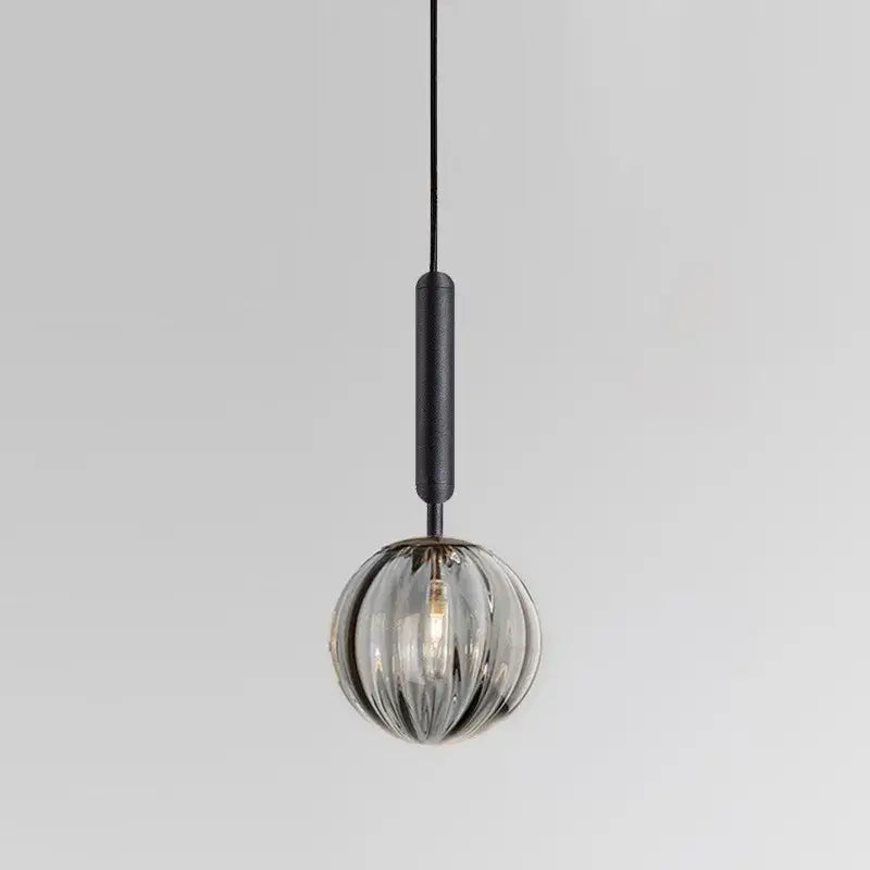 Modern multi color glass pendant light with sleek spherical glass, painted iron finish, and textured black cord for dining room
