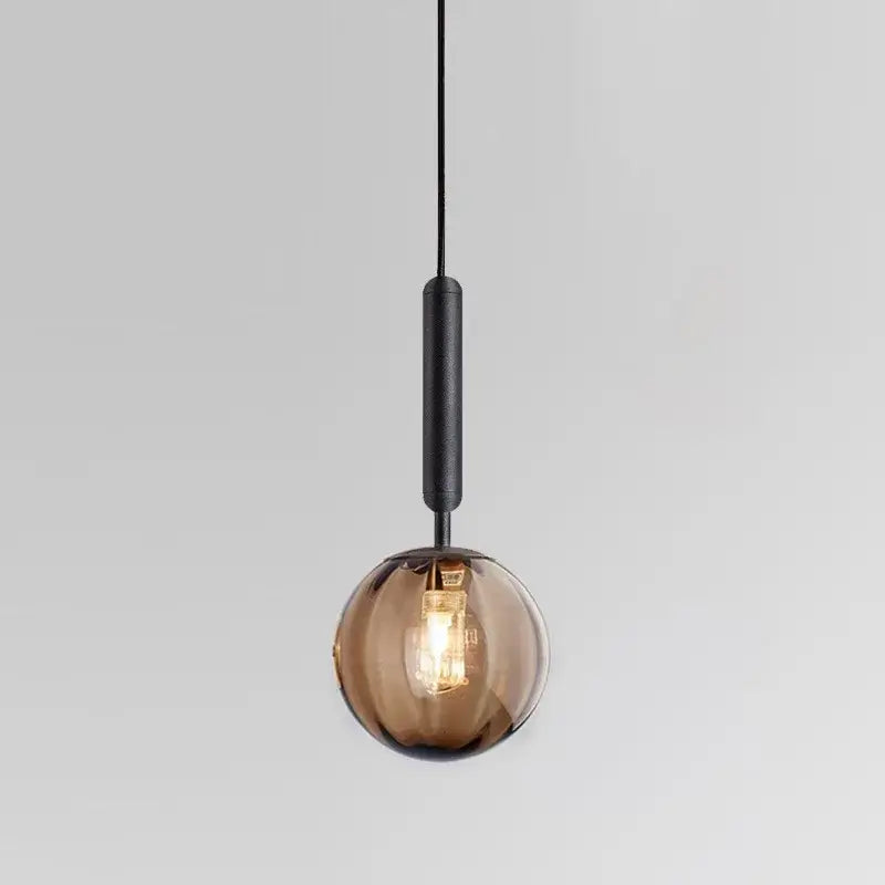 Modern multi color glass pendant light with amber glass globe and painted iron matte black stem for dining room use