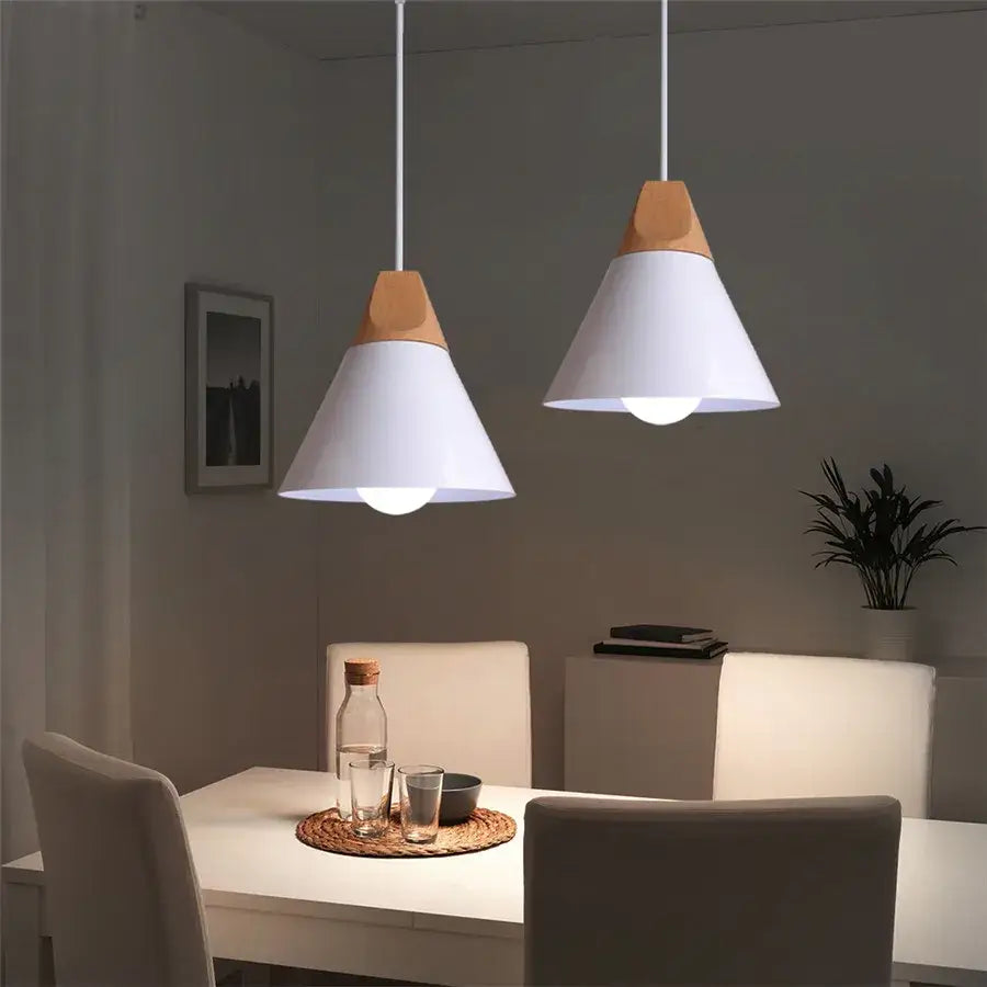 Two modern white cone wood pendant lights with light wood accents by decorbites hang above dining table