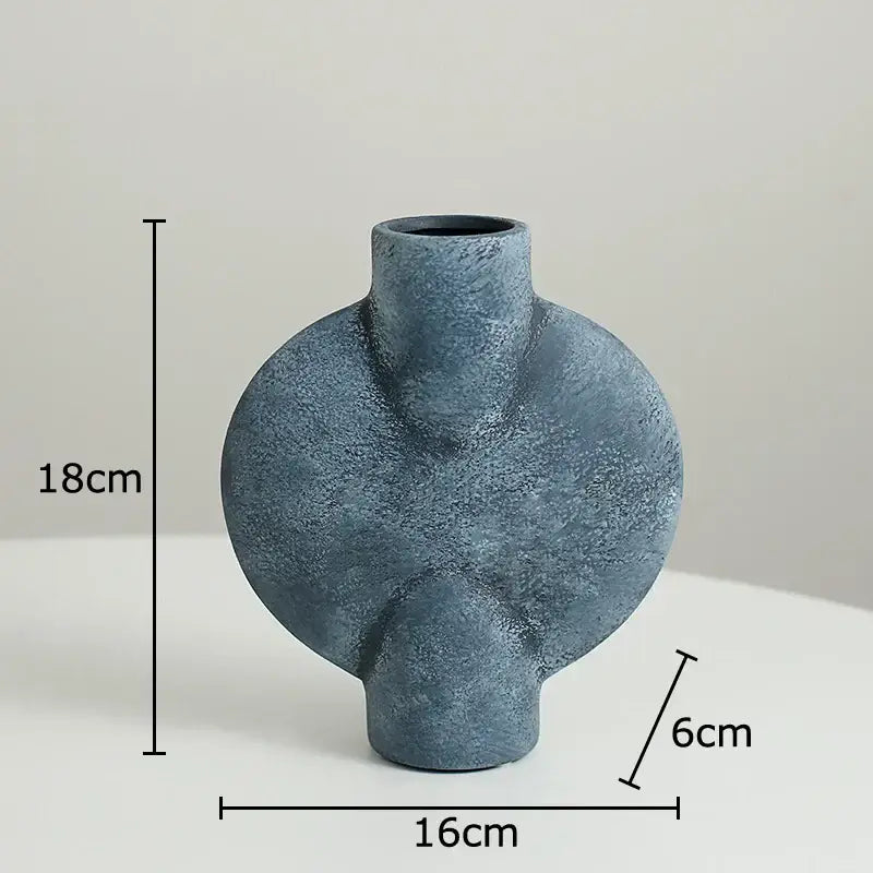 Matte blue ceramic disc vase with textured asymmetrical design and rounded contours for modern decorbites ceramic decor