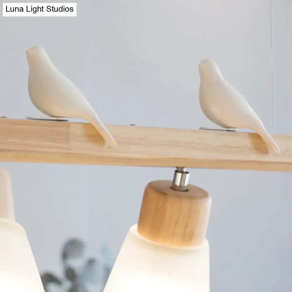 Two minimalist white ceramic birds perched on a light wood beam of a natural wood rectangle island pendant light
