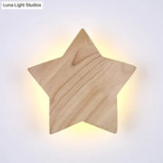 A warm glowing modern natural wood star wall lamp with visible grain designed for living room sconce lighting