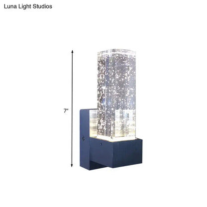 Modern navy blue wall sconce with a clear crystal bubble glass column and 7-inch fixture width for bedroom use