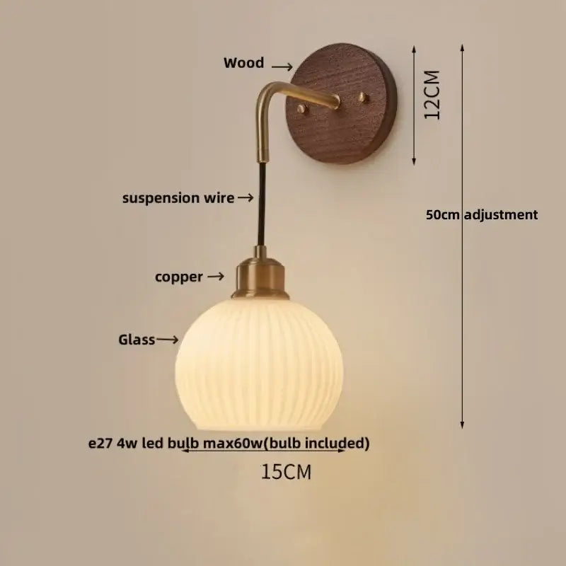Modern nordic copper adjustable led wall light with warm-toned glass globe and brass-finished arm on dark wood plate