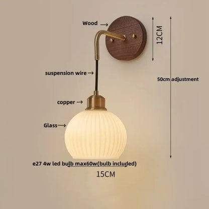 Modern nordic copper adjustable led wall light with warm-toned glass globe and brass-finished arm on dark wood plate