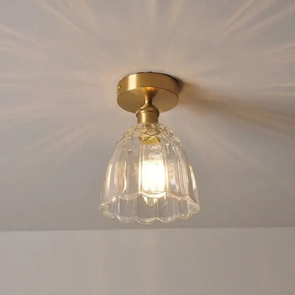 A modern nordic gold glass flower led ceiling light with clear fluted glass and brass finish for bedroom use