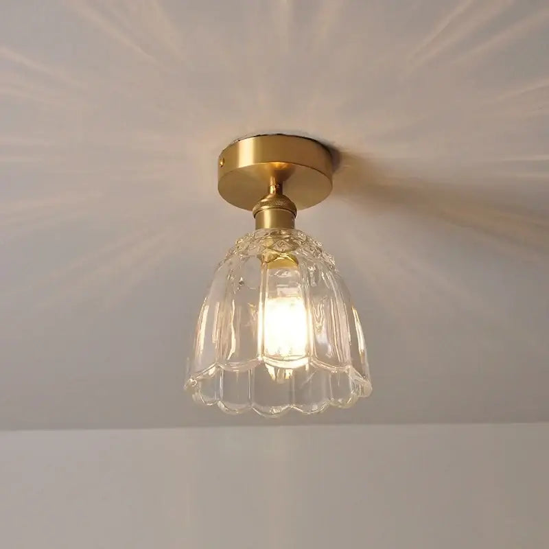 A modern nordic gold glass flower led ceiling light with clear fluted glass and brass finish for bedroom use