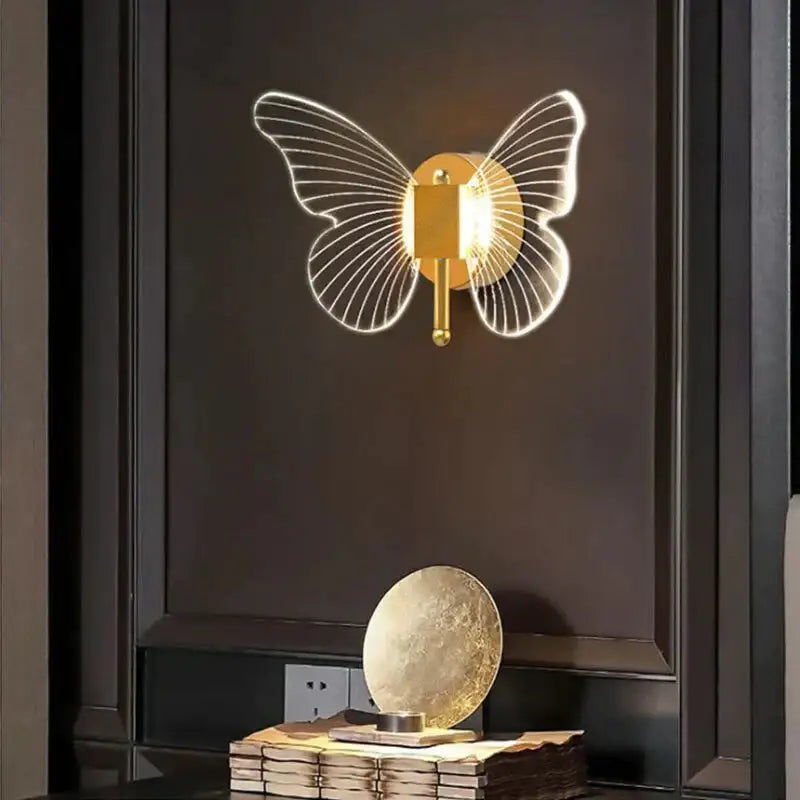 Modern nordic gold led butterfly wall lamp with illuminated translucent wings and sleek metallic body for bedroom use