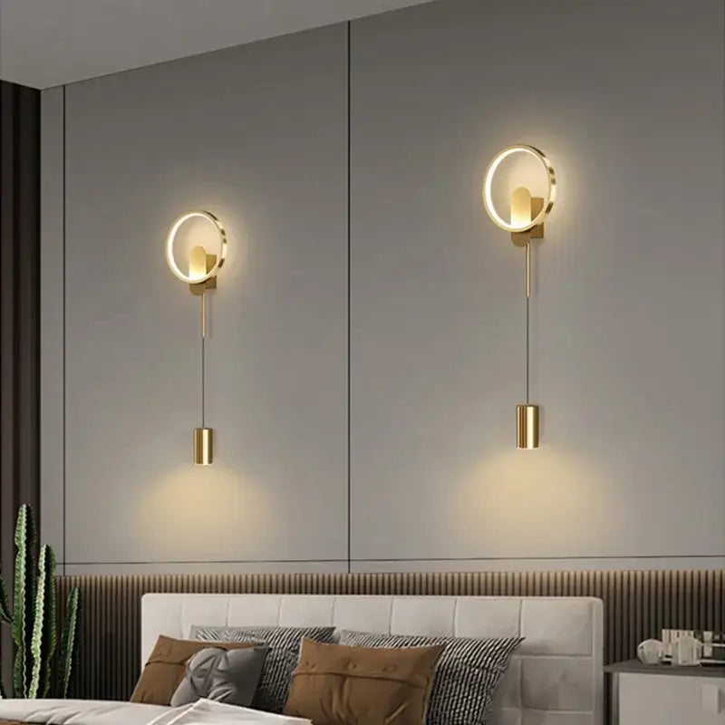 Modern nordic gold led wall light featuring circular gold-toned wall lamp with sleek hanging cylindrical fixtures by decorbites