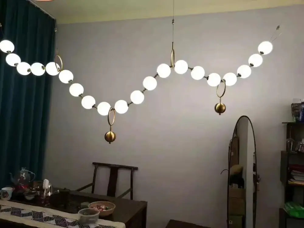 Modern nordic led pendant lamp with spherical white glass bulbs and brass metal rings for dining room decorbites nordic led