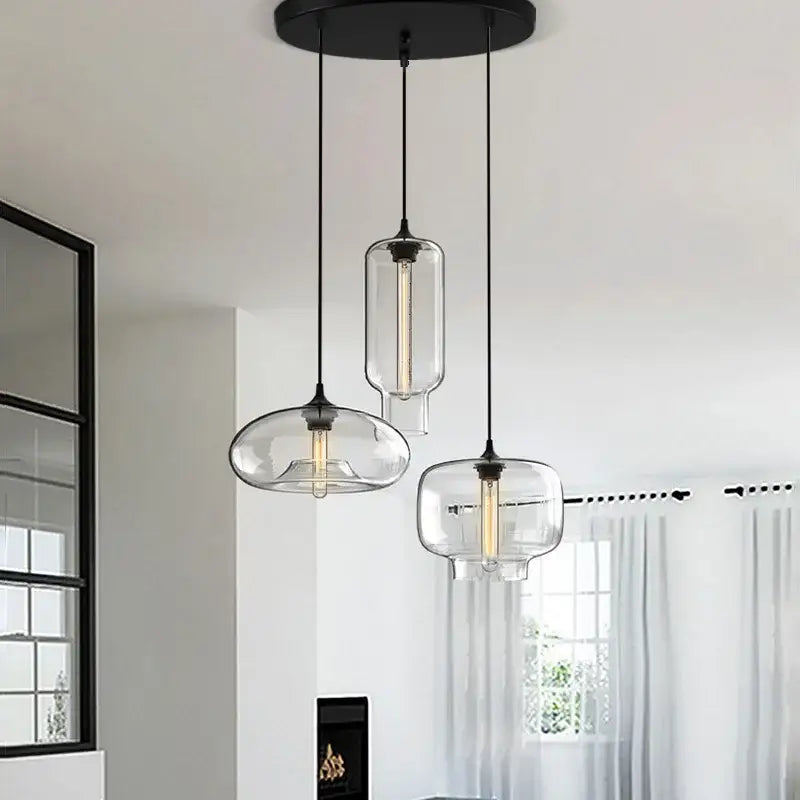 Modern black pendant light with three clear glass shades, polished chrome accents, and led filament bulbs for kitchen use
